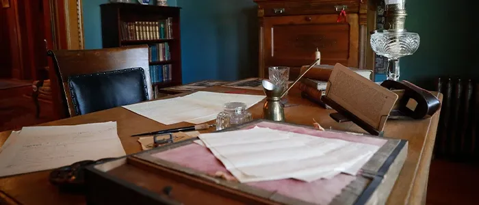 a photo of an antique desk with papers on it